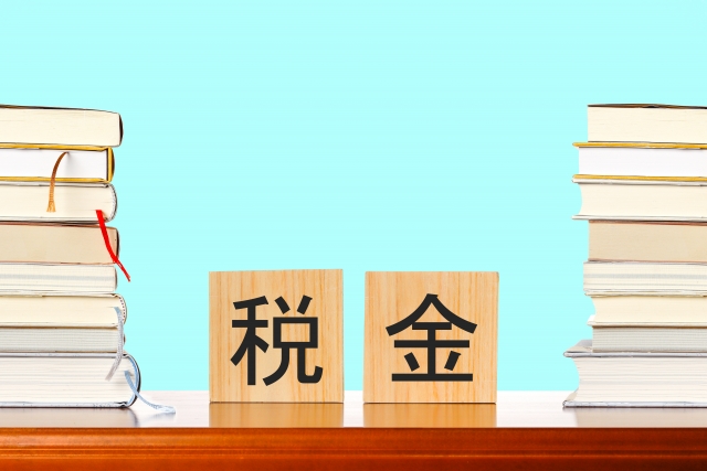 税金と書かれたブロックと積まれた本