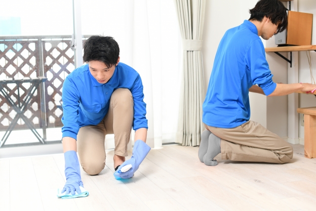 部屋を掃除している男性作業員